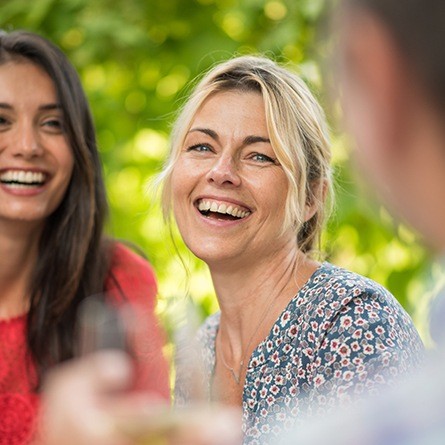 woman laughing outside with friends