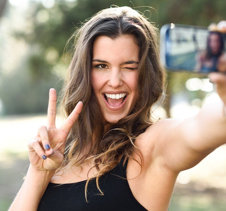 woman taking selfie doing peace sign