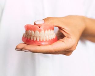 dentist holding dentures