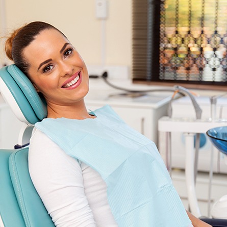 Woman sitting in dental chair and smiling