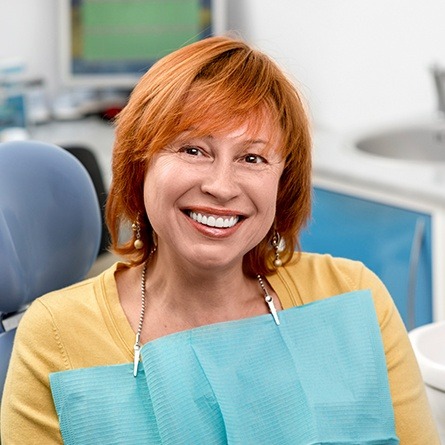 woman in yellow smiling at camera