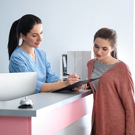 girl at front desk looking at paperwork