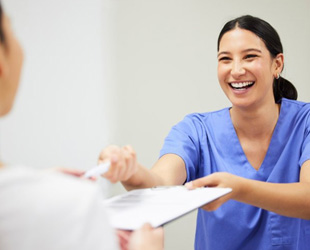 Dental staff member smiling at patient 