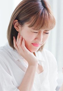 Patient in Helotes holding cheek due to tooth pain