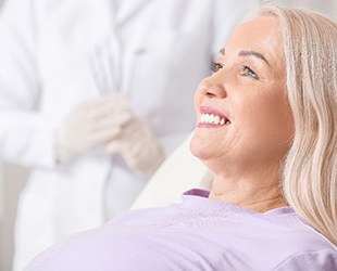 woman smiling while sitting in dental chair 
