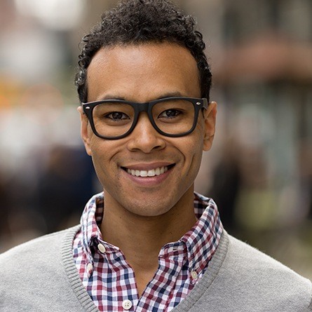 man with glasses smiling at camera