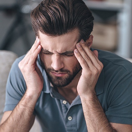 man holding head in pain