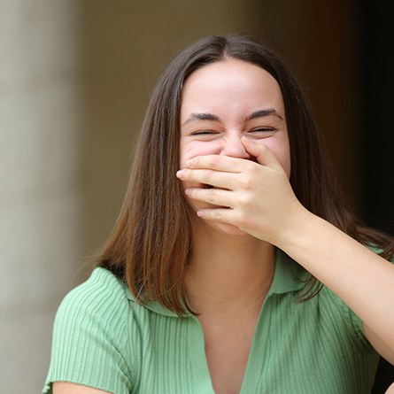 Woman using her hand to cover her smile
