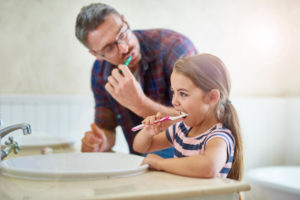 dad daughter brushing teeth