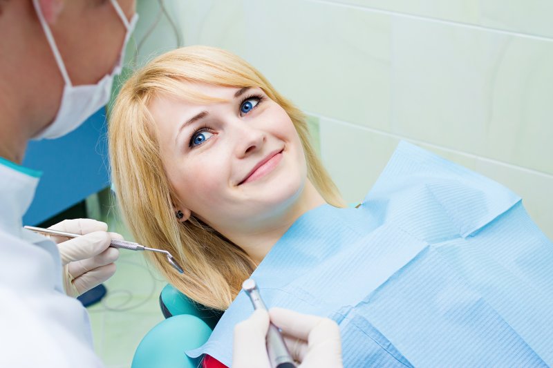 A young woman having her teeth checked by the dentist