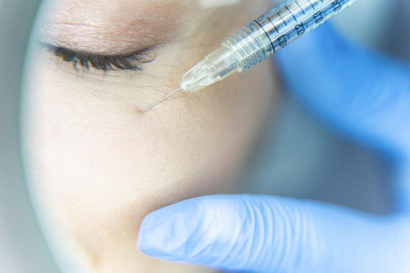 a person receiving a dermal filler injection near their eye