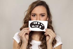 woman holding picture of incomplete smile