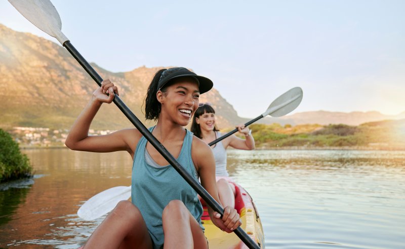 two friends kayaking on lake 