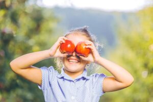 Happy child holding two apples 