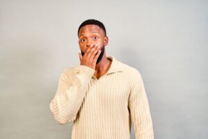 Shocked man covering his mouth